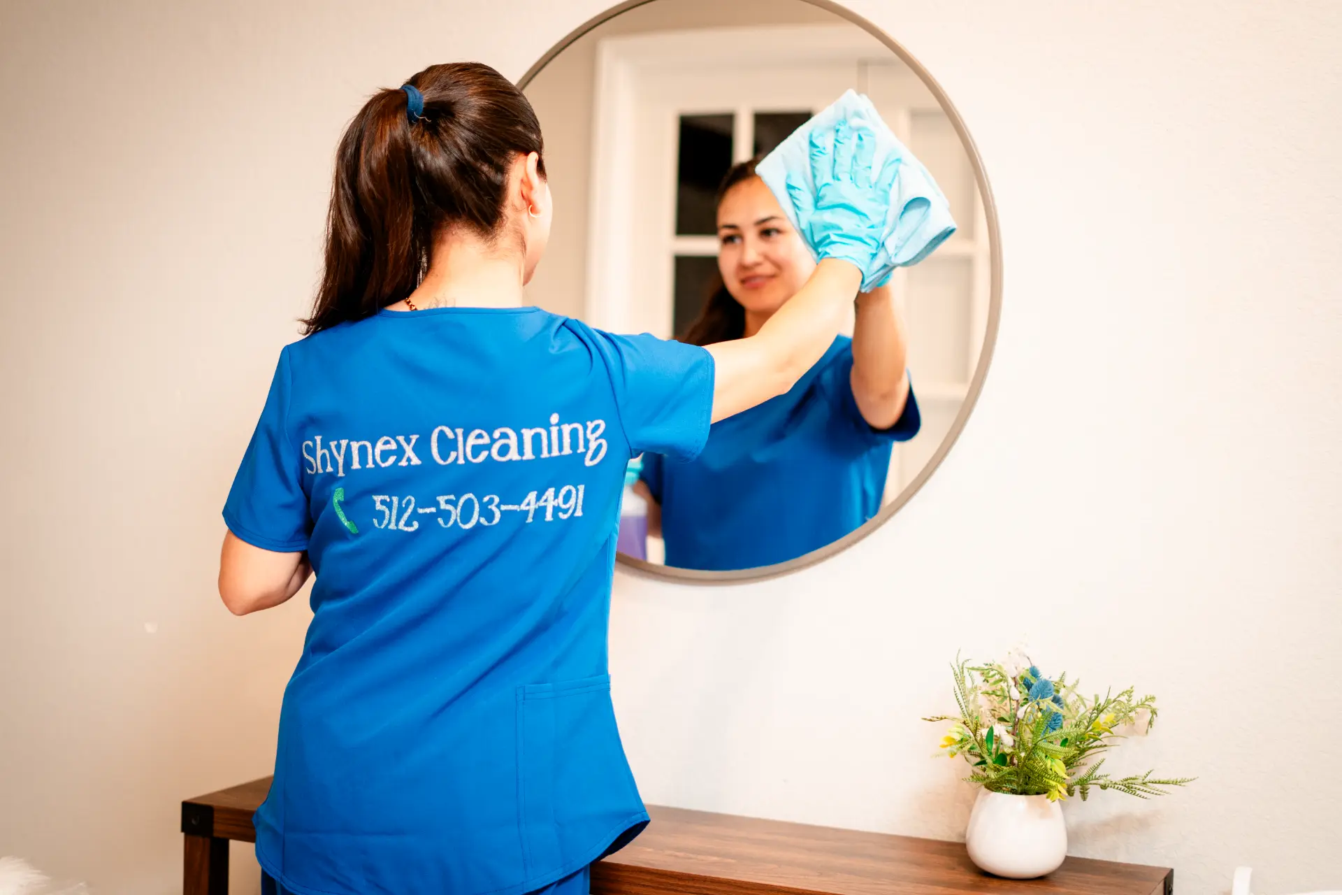Shynex Cleaning staff polishing a round mirror during a house cleaning in Austin, TX